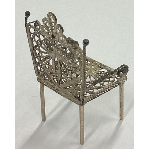 113 - A silver filigree toy chair. Approx. 2 grams. Est. £20 - £30.