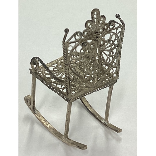 115 - A silver filigree toy rocking chair. Approx. 3 grams. Est. £20 - £30.