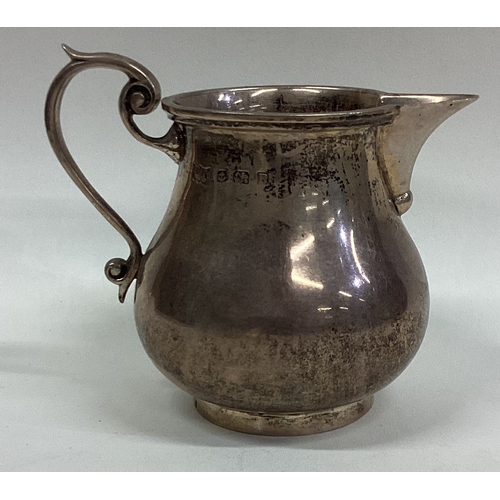 214 - A good heavy silver cream jug of shaped form in the Georgian style. Birmingham. By M&W. Approx. 131 ... 