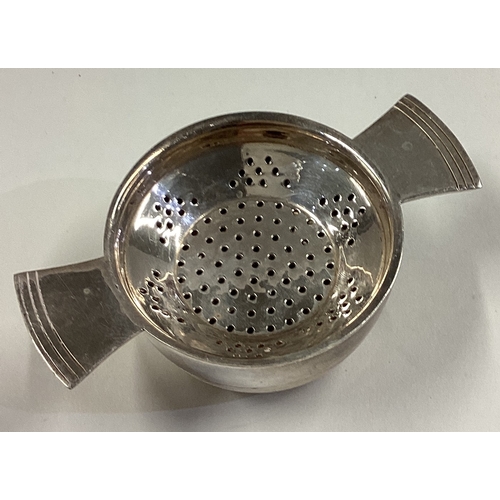 22 - A silver plated tea strainer on stand. Est. £30 - £50.