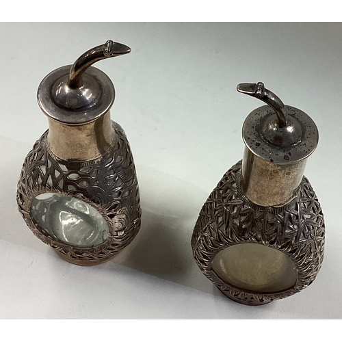 481 - A pair of Chinese silver and glass decanters embossed with bamboo decoration. Marked Sterling. Appro... 