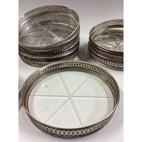 55 - A set of twelve silver bottle coasters with glass bottoms. Est. £200 - £250.