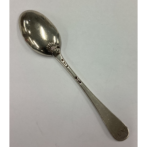 563 - An 18th Century silver shell back spoon. Maker's and lion mark only. Approx. 5 grams. Est. £20 - £30... 