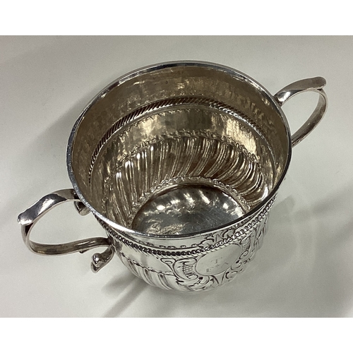 565 - An 18th Century silver porringer of fluted form. Marked to base. London 1728. By Richard Bayley. App... 