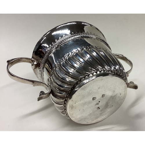 565 - An 18th Century silver porringer of fluted form. Marked to base. London 1728. By Richard Bayley. App... 