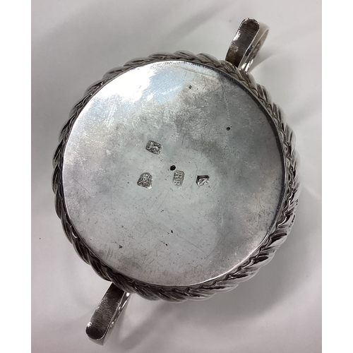 565 - An 18th Century silver porringer of fluted form. Marked to base. London 1728. By Richard Bayley. App... 