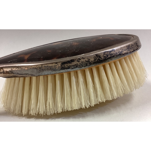 57 - A silver mounted and tortoiseshell clothes brush. Birmingham. Est. £20 - £30.