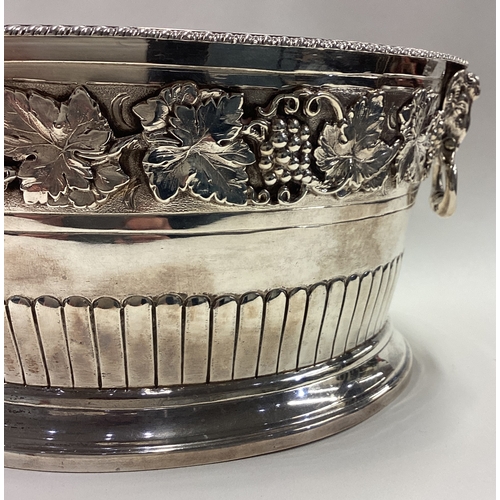 738 - A rare early 20th Century silver ice bucket embossed with grape and vine decoration and cast with ra... 