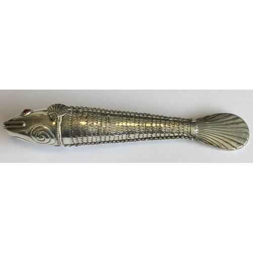 781 - A silver articulated figure of a fish with red eyes. Approx. 76 grams. Est. £120 - £150.