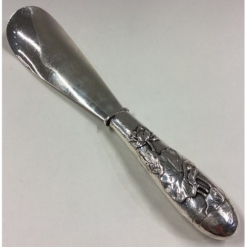 95 - A Japanese silver shoe horn decorated with chased rose water lilies to handle. By Arthur & Bond. App... 