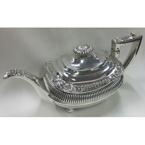 516 - A heavy George III silver half fluted teapot with shell and leaf decoration. London 1815. By Emes & ... 