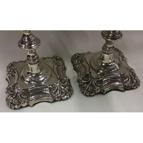 254 - A pair of William IV silver candlesticks with crested decoration. Sheffield 1834. By Thomas, James &... 