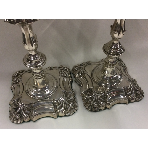 254 - A pair of William IV silver candlesticks with crested decoration. Sheffield 1834. By Thomas, James &... 