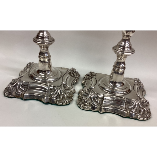 254 - A pair of William IV silver candlesticks with crested decoration. Sheffield 1834. By Thomas, James &... 