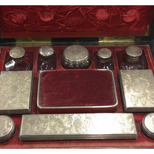 796 - A good quality Victorian silver mounted travelling set of scent bottles contained within wooden case... 