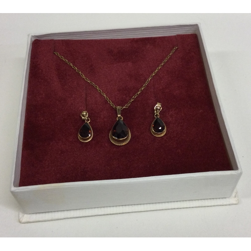 810 - A small garnet pendant together with matching earrings. Approx. 2 grams. Est. £20 - £30.