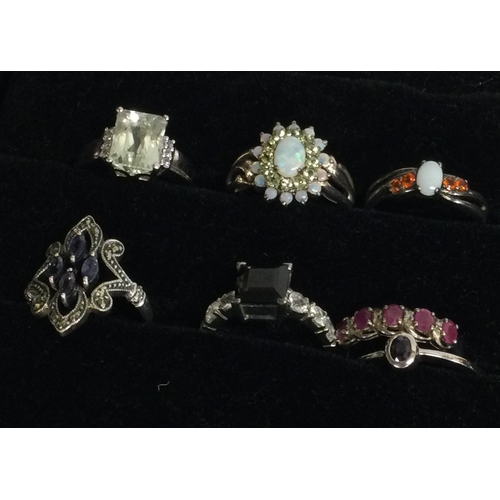 829 - A group of seven silver and gem set rings. Est. £15 - £20.