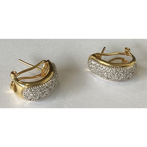 853 - A pair of 18 carat gold diamond set earrings in two colour. Approx. 4 grams. Est. £100 - £150.