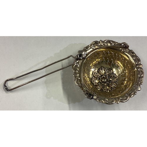 146 - A 19th Century French silver gilt tea strainer / infuser with chased decoration. Marked to side. App... 