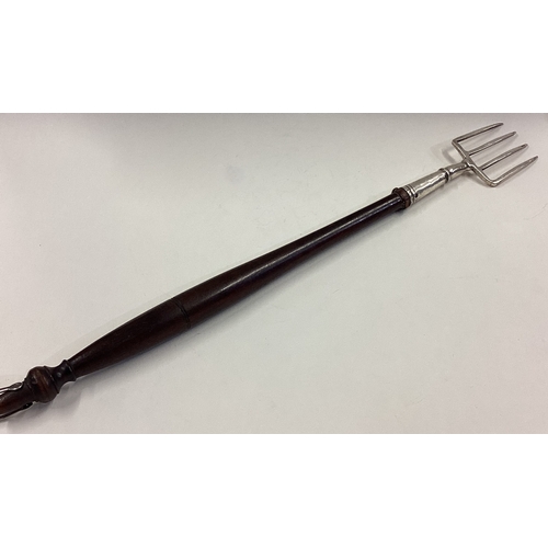 160 - A large 19th Century Georgian silver toasting fork with wooden handle. Approx. 100 grams of gross we... 