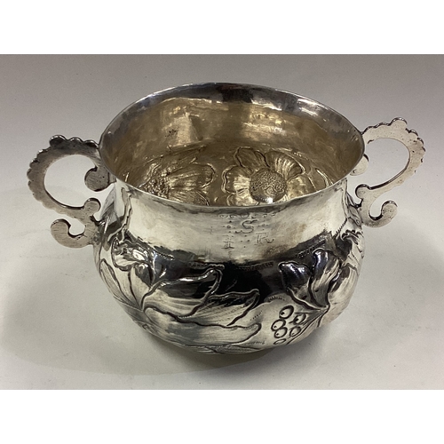 239 - A Charles II Provincial silver porringer with overshaped s-scroll handles. Struck three times with r... 