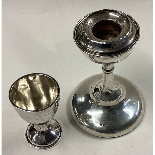 306 - A plain Edwardian silver candlestick together with a small trophy cup. Various dates and makers. App... 