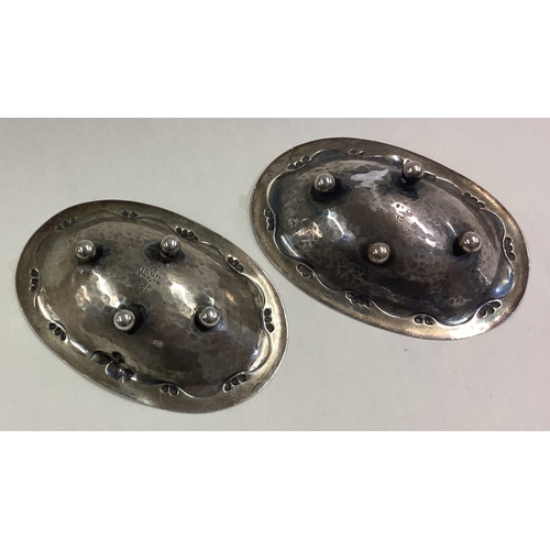 31 - GEORG JENSEN: A pair of chased silver dishes on feet. Approx. 34 grams. Est. £100 - £150.