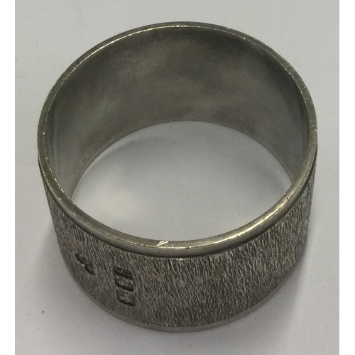 332 - A silver napkin ring with bark decoration in the style of Gerald Benney. London 1963. By Wakely & Wh... 