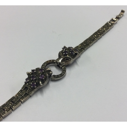 374 - A silver bracelet decorated with amethyst studded panther heads in the style of Cartier. Approx. 25 ... 