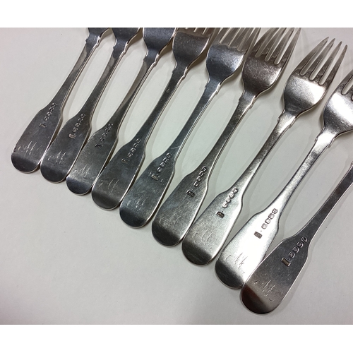 402 - A matched set of nine heavy silver fiddle pattern table forks. London. By WE. Approx. 630 grams. Est... 