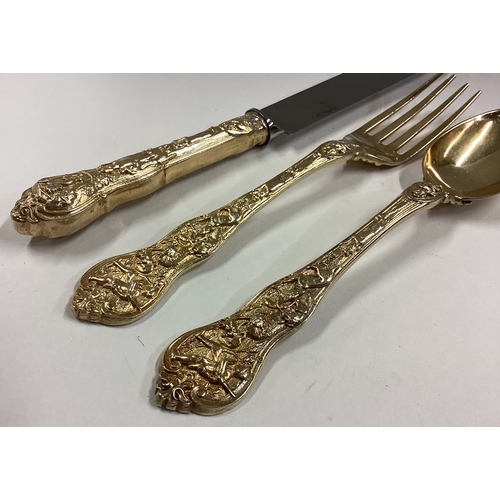 500 - A Victorian silver gilt Bacchanalian pattern christening knife, fork and spoon set. Approx. 182 gram... 