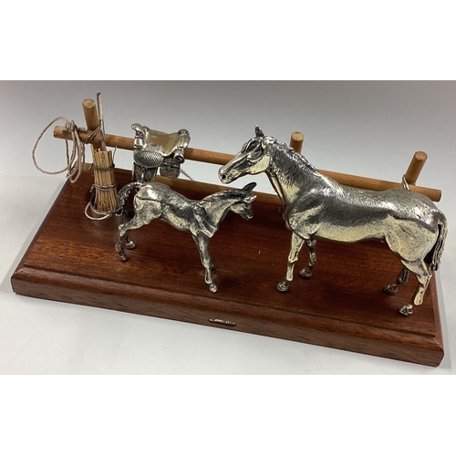 520 - A cased silver figure of a horse and foal on wooden stand. Est. £200 - £300.