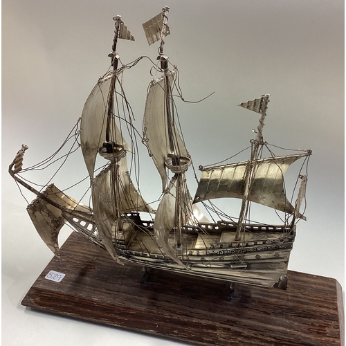 529 - A Continental silver model of a galleon on wooden base. Est. £300 - £400.