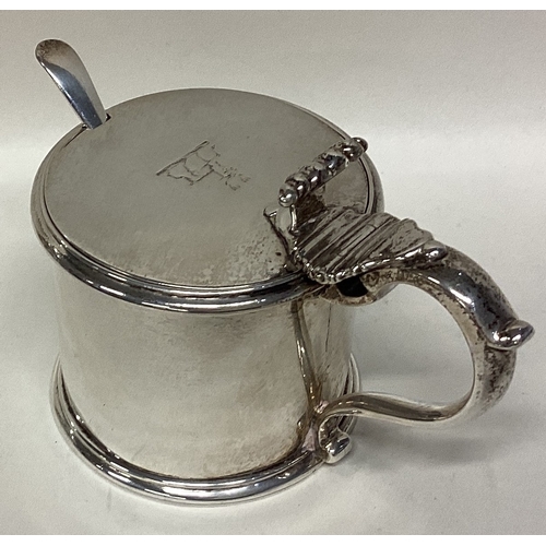 563 - A good quality heavy Victorian silver mustard pot with scroll thumbpiece and crested lid. London. By... 