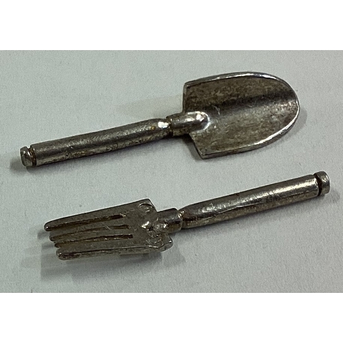 571 - A silver toy hand trowel and fork set. Approx. 3 grams. Est. £20 - £30.