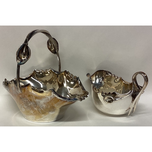 702 - A heavy silver sugar basket together with a matching cream jug decorated with calla lilies. Sheffiel... 