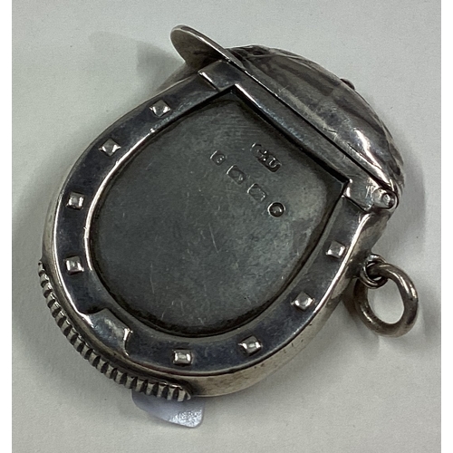 713 - An unusual silver vesta case in the form of a jockey's cap with horseshoe border. Birmingham 1880. B... 