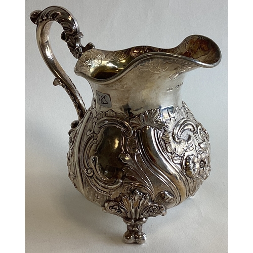 785 - A fine quality chased Victorian silver cream jug with scroll decoration to gilt interior. London. By... 