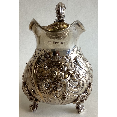 785 - A fine quality chased Victorian silver cream jug with scroll decoration to gilt interior. London. By... 