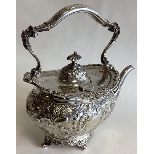 788 - A heavy chased silver teapot with floral decoration on four cast feet. London. By LS. Approx. 893 gr... 