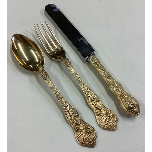 500 - A Victorian silver gilt Bacchanalian pattern christening knife, fork and spoon set. Approx. 182 gram... 