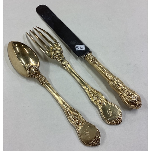 500 - A Victorian silver gilt Bacchanalian pattern christening knife, fork and spoon set. Approx. 182 gram... 