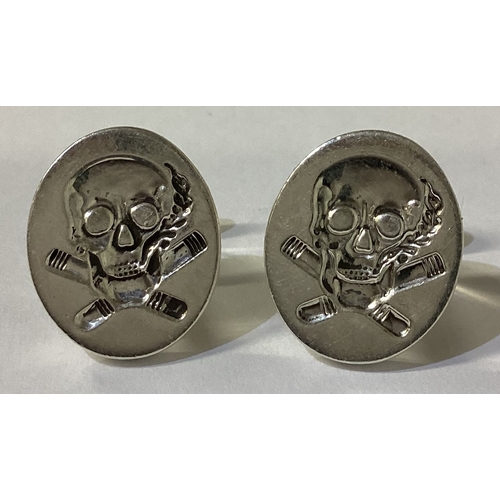 102 - A pair of Sterling silver cufflinks engraved with skull decoration. Approx. 21 grams. Est. £20 - £30... 