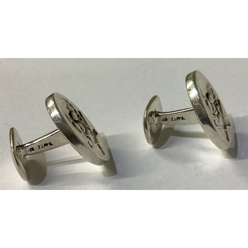 102 - A pair of Sterling silver cufflinks engraved with skull decoration. Approx. 21 grams. Est. £20 - £30... 