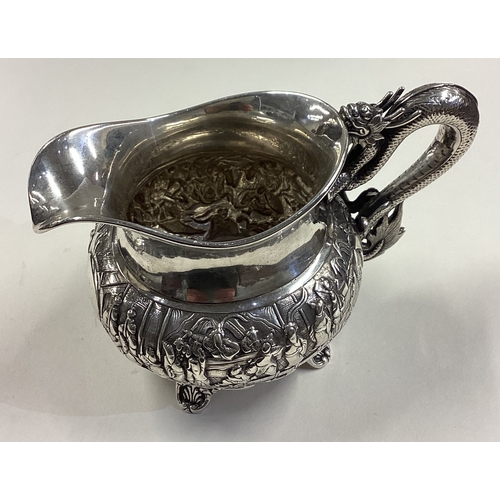 174 - A rare Chinese export silver jug with figural dragon handle embossed with fighting scenes. Circa 186... 