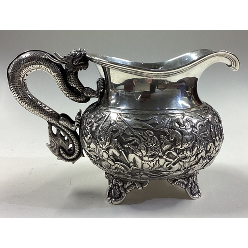 174 - A rare Chinese export silver jug with figural dragon handle embossed with fighting scenes. Circa 186... 