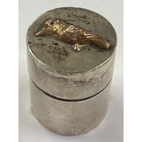 241 - An Australian silver and gold pill box chased with bird decoration. Approx. 24 grams. Est. £100 - £1... 