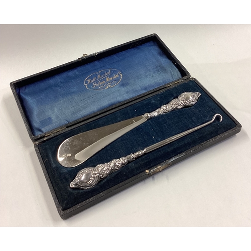 273 - A cased silver shoe horn and hook. Birmingham 1910. Approx. 62 grams. Est. £30 - £40.