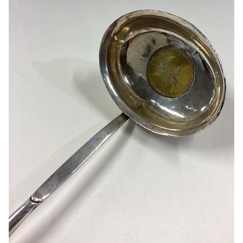 312 - A large 19th Century silver toddy ladle with gilt coin to centre. Approx. 49 grams. Est. £40 - £60.