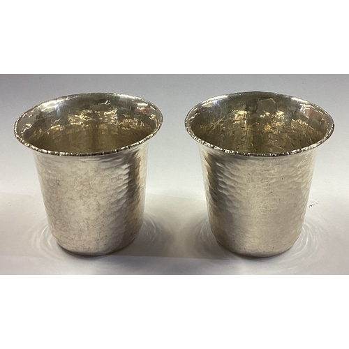 322 - A pair of Continental silver stacking shot cups with hammered decoration. Approx. 52 grams. Est. £40... 